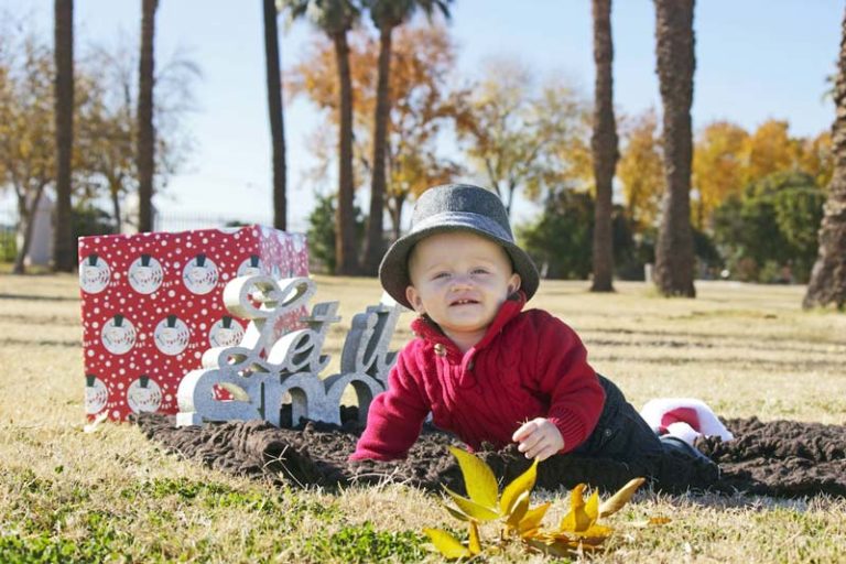 outdoor photography of young son before christmas in fall weather and warm clothes grass with holiday season props for parents in olive branch mississippi by danielle jacqueline