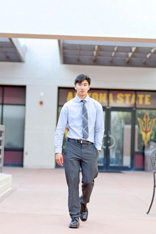 confident graduating senior walking poses with school information and formal attire for parents keepsake in desoto county ms