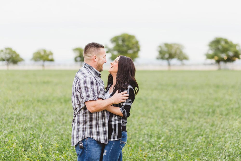 husband and wife dancing in the open prairie on olive branch mississippi farm with apple trees in background natural pose candid moment by danielle jacqueline photography