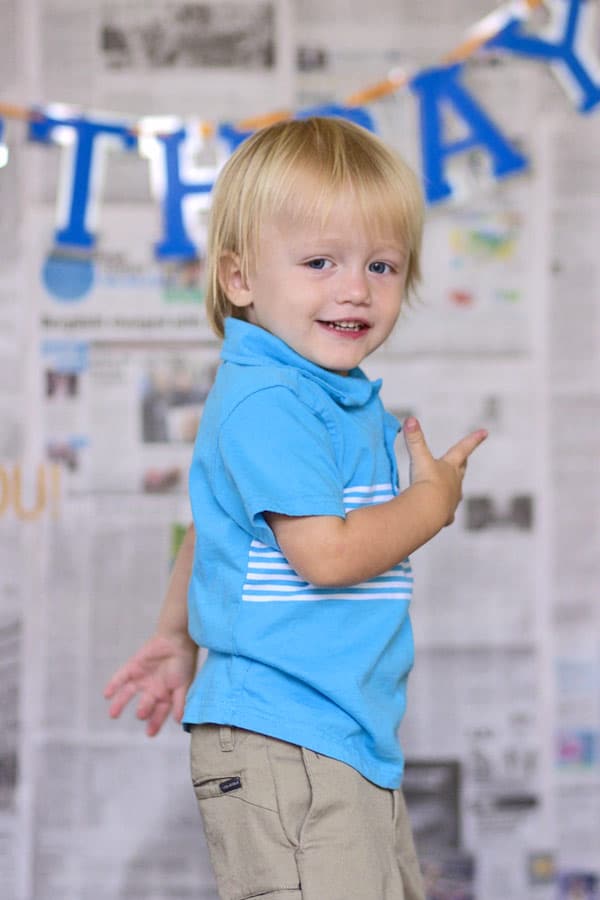 young boy pointing behind him as if he's going to run away during terrible twos birthday themed photoshoot in olive branch mississippi by danielle jacqueline