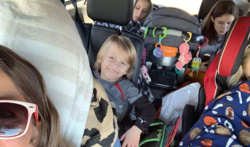 son of family of 8 riding in middle seat during road tip across country to indianapolis for thanksgiving travels tips from danielle jacqueline photography