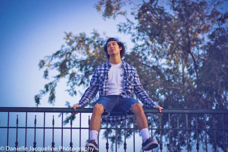 seated on the edge of life with senior boy photo ideas for free spirit carefree teens looking to the adventure of adulthood ahead with photographer danielle jacqueline near memphis tennessee