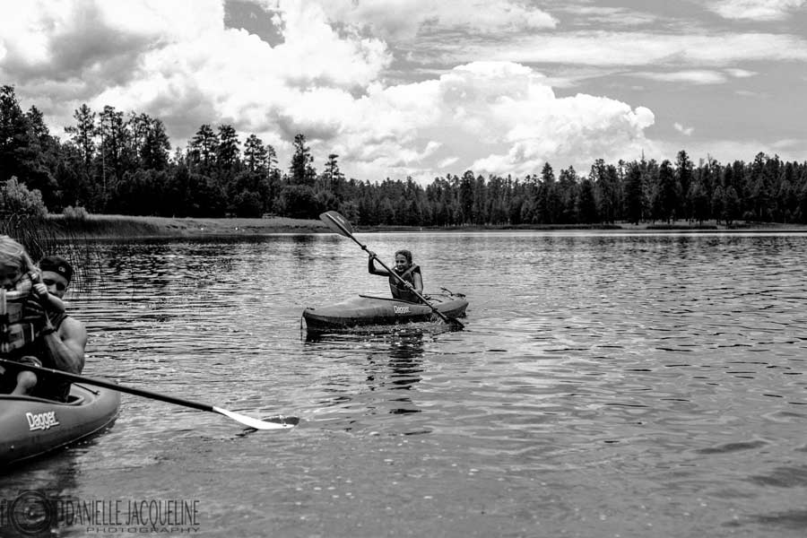 lifestyle photography session with family outdoors in northern mississippi going fishing on kayaks with dad and danielle jacqueline black and white portrait on the water