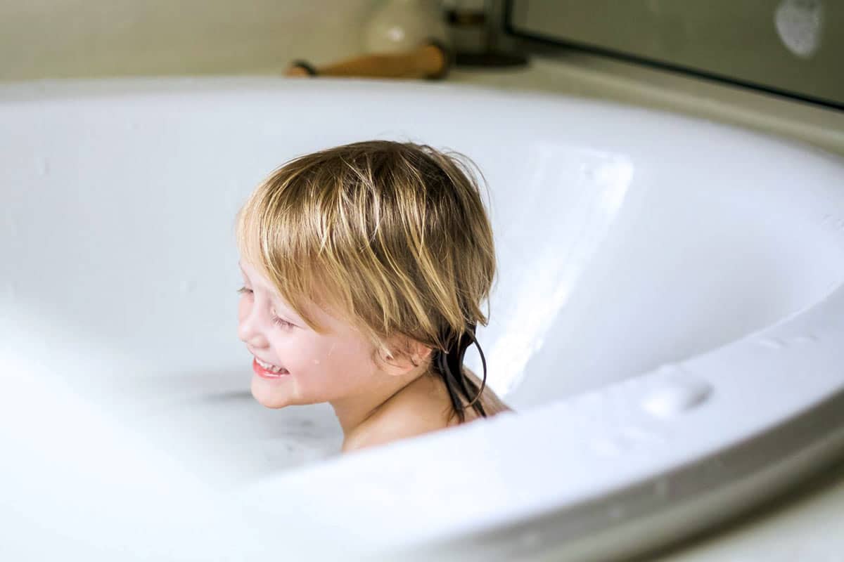 big tub at home during capturing life with photographer kids cleaning up after dinner for parents in home photo shoots with professional in memphis tn danielle jacqueline candid