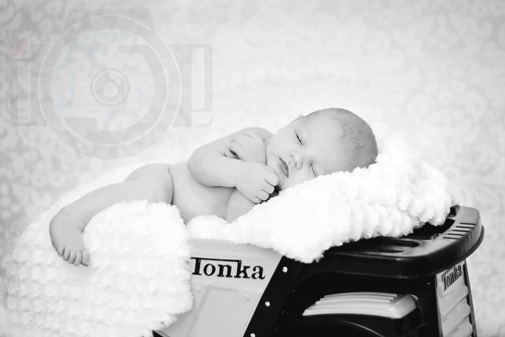 close up of baby boy almost asleep on toy prop during portrait session indoors with danielle jacqueline black and white olive branch ms