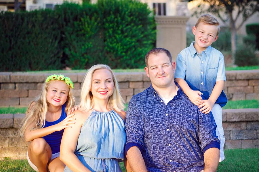 family picture near direct sunlight warming effect on hot summer day after big move to new city by olive branch photographer danielle jacqueline brick steps and grass with green shrubs in background