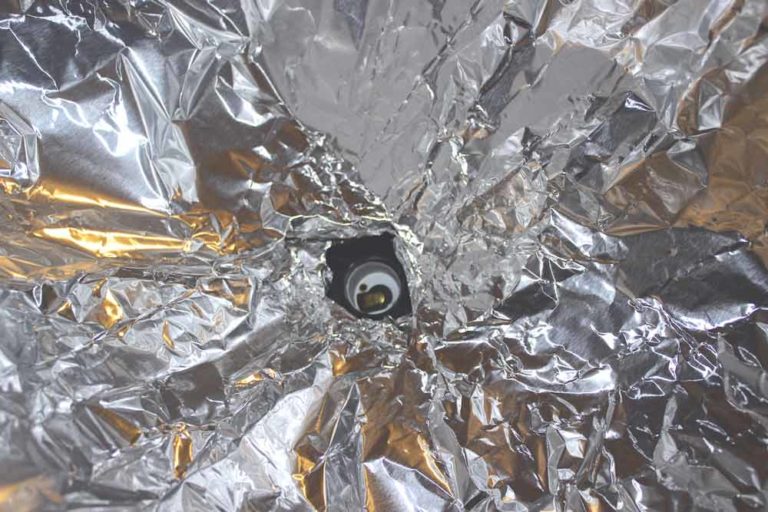 center of aluminum foil reflective surface for inside of diy studio lighting before light bulb is placed into socket for home project with danielle jacqueline photography in olive branch ms