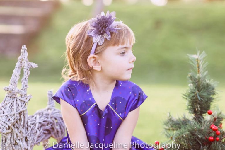 looking right in purple dress center of attention for outdoor winter family photo session by danielle jacqueline now located south east of memphis tennessee