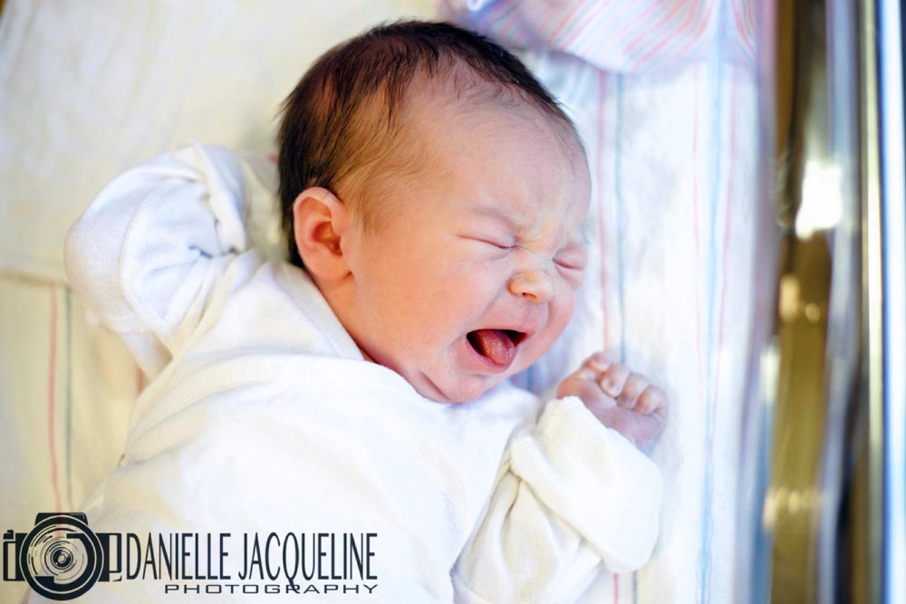 hand behind head laying on hospital bed crying for mommy after birth captured by danielle jacqueline photography fresh 48 in desoto county mississippi memphis area