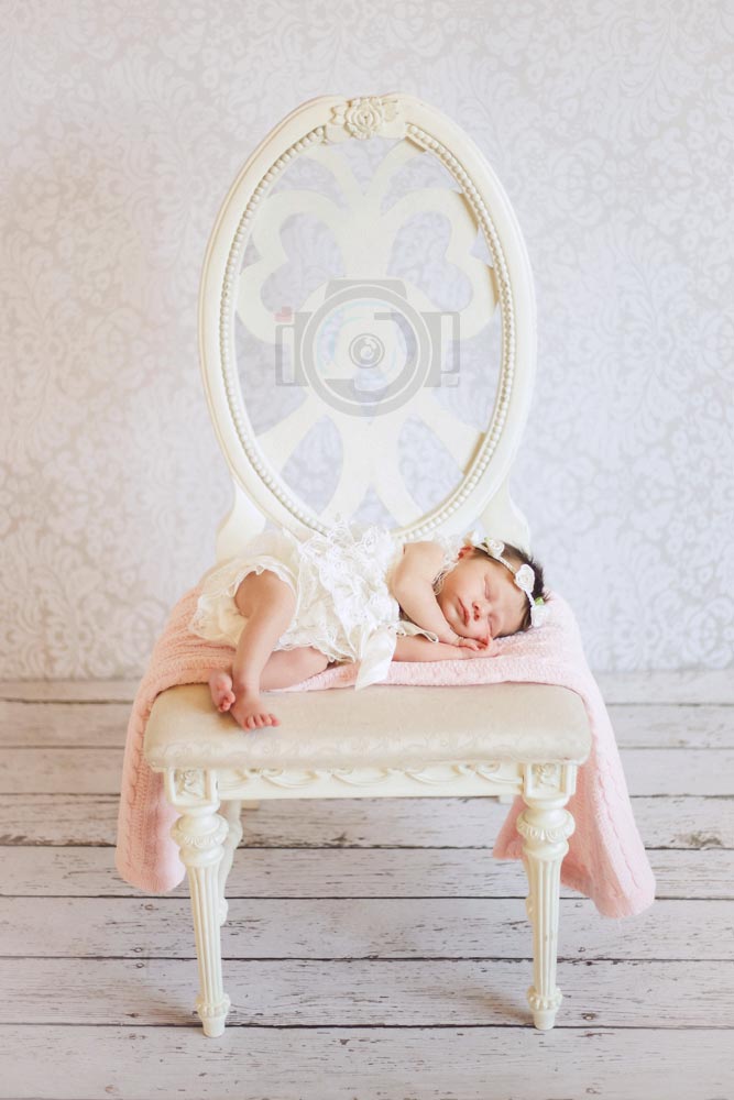 full chair picture with wooden floor planks and white backdrop at studio session with danielle jacqueline in memphis tn for newborn baby girl photo ideas vertical for parents professional