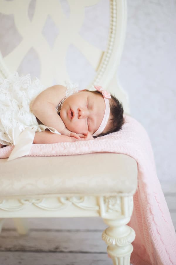 close up image of side of little baby daughter laying on the seat of a chair on hands sound asleep at danielle jacqueline photography studio south of memphis tn