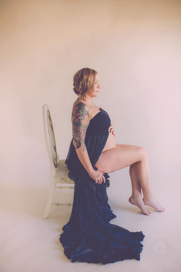 maternal mother facing right in dark wrap around belly elegant chair studio portraits by danielle jacqueline for moms south of memphis tennessee studio pro