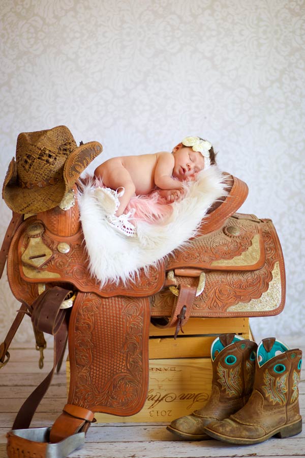 new baby photo session ideas for girls huge brown leather saddle stirrups and cowgirl boots for photography theme at studio natural lighting by danielle jacqueline memphis tennessee babies