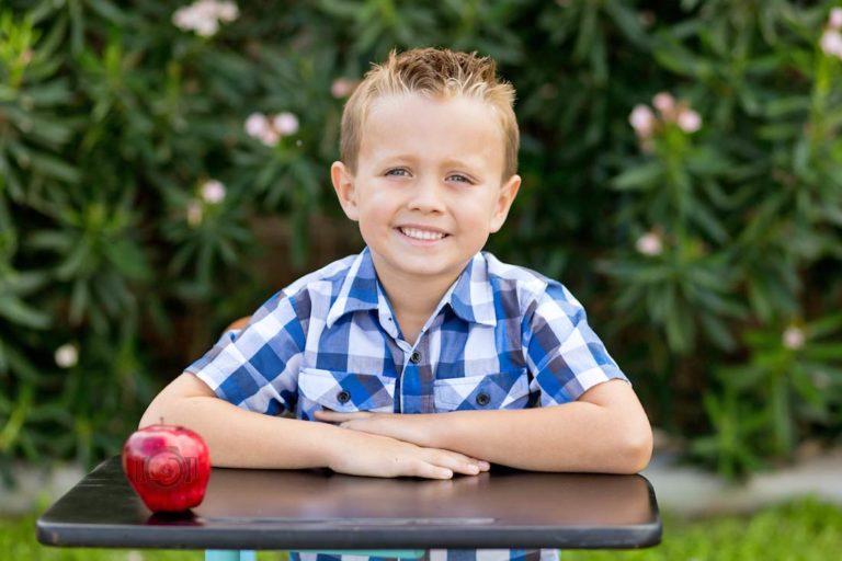 apple situated on corner of classic schoolhouse desk with bright eyed preschooler all smiles well dressed for class pictures in memphis tennessee by danielle jacqueline photography