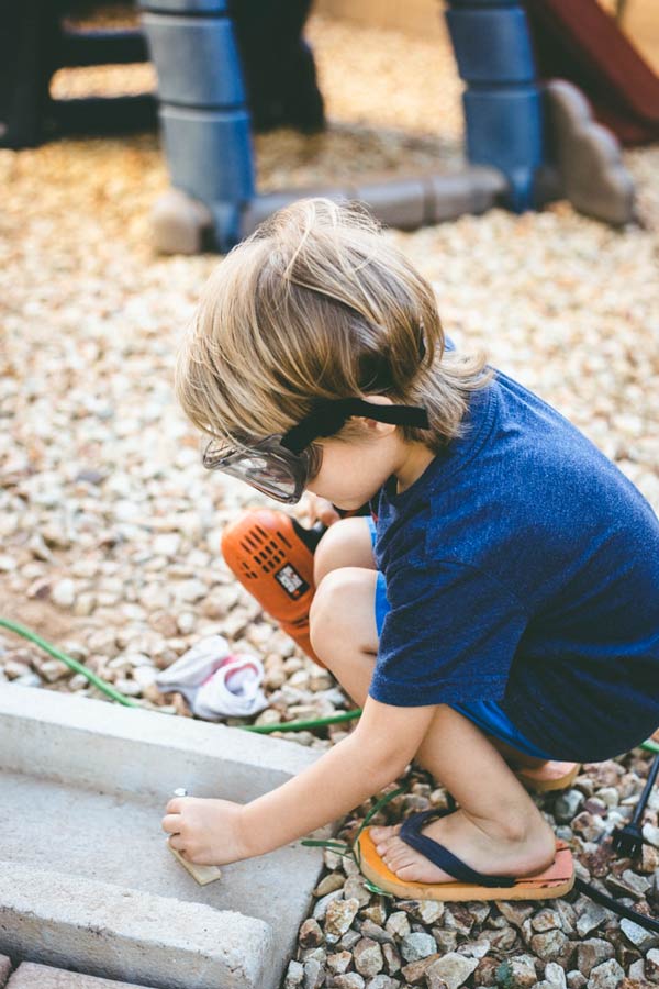 my little boy trying to bolt a small piece of wood into the concrete with power drill life as a mississippi mother djp