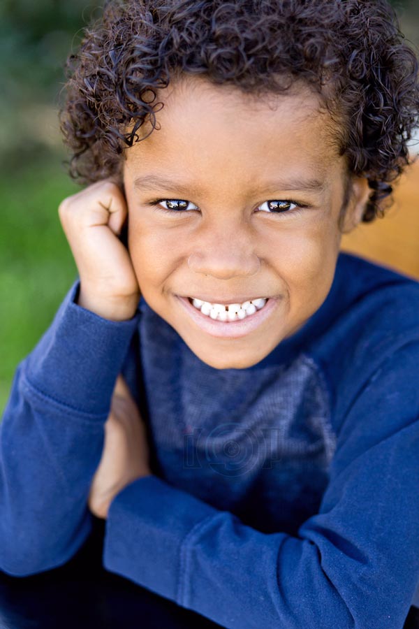 close up portrait of 6 year old memphis tn preschooler looking right at camera grass in background angled down for personal look by danielle jacqueline photography