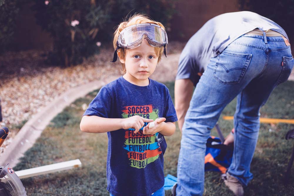 curious look to mommy but serious helping daddy outside photography ideas for families in olive branch ms