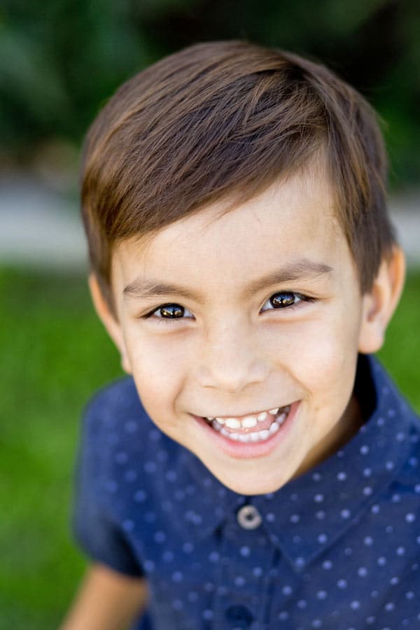 50mm lens portraits of preschool boy in blue polka dot button up looking up at camera with combed hair in memphis tennessee with danielle jacqueline photography