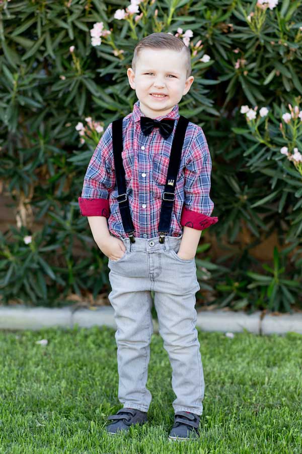 cute little boy dressed to impress in front of shrubbery outside school for class pictures with danielle jacqueline photography in desoto county mississippi