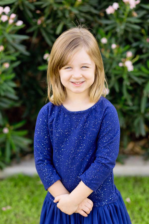 adorable blue dress preschool portraits natural smile little girl in front of green background with grass for individual by danielle jacqueline photography in collierville tennessee