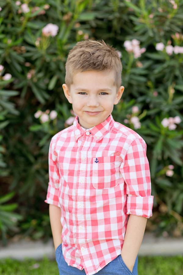 red and white checkered shirt jeans standing in grass outside school for pre-k class pictures by danielle jacqueline photography in memphis tennessee