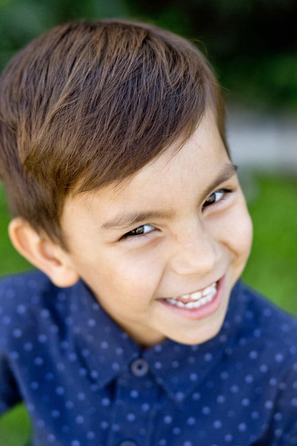 tilted head of preschool boy looking up at camera with huge natural smile comfortable with danielle jacqueline photography in memphis tn