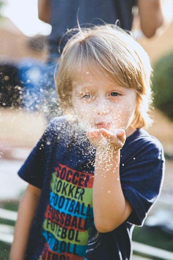 sawdust floating in the air from breath of young boy during backyard photoshoot with momma photographer in desoto county ms