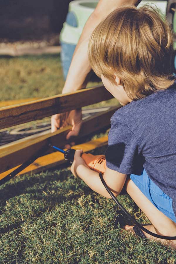 golden hour capturing son working outside on carpenter project with dad in olive branch ms