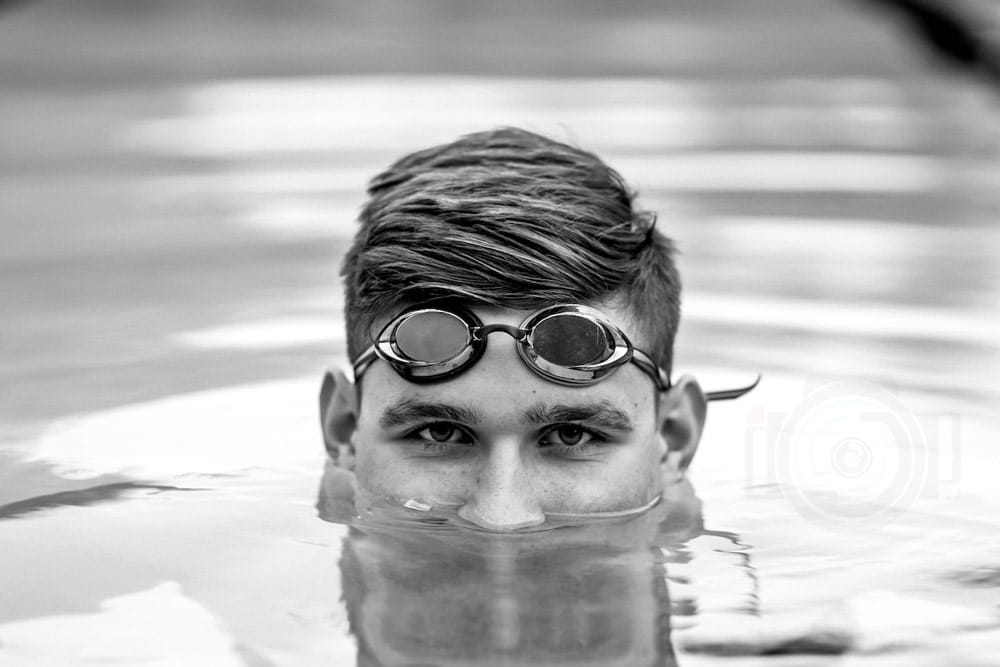 serious high school senior photography ripples of water covering half face student athlete swimmer portraits black and white near memphis tn