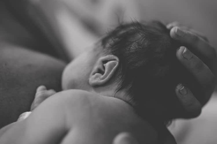 close up of newborn infant feeding with mother during photography shoot with danielle jacqueline intimate moments black and white photo olive branch services mississippi