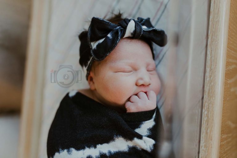 gorgeous baby girl navy blue bow and blankie angled photography shot hand clinched in mouth eyes closed after birth by danielle jacqueline out of olive branch mississippi