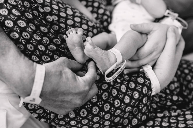 black and white photo of first time parents enjoying their fresh born baby girl at hospital with danielle jacqueline photography in olive branch ms