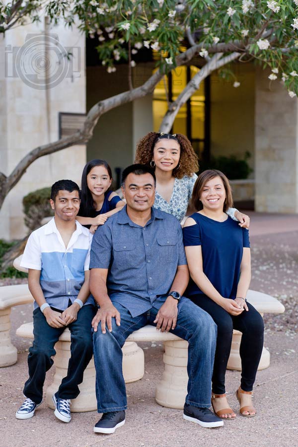 family portrait on father's day with daddy in the middle all wearing dark blue for concrete and brick setting outdoors in urban environment to celebrate togetherness since half unit is split up most the year memphis imagery