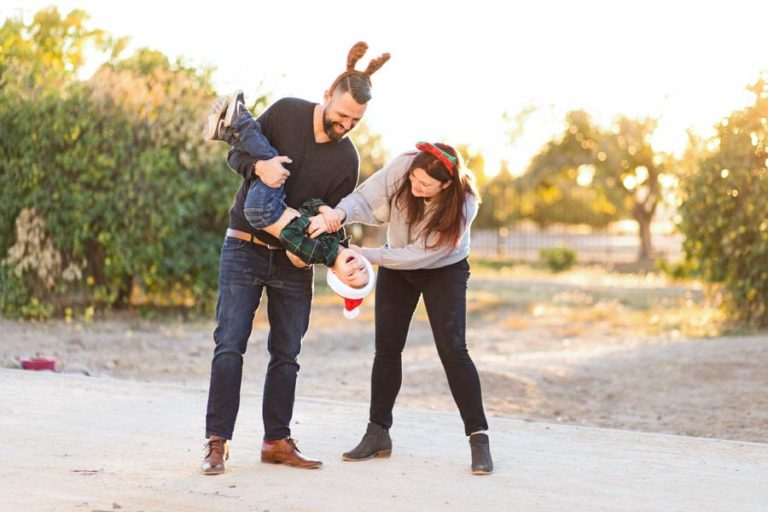 mom and dad having fun with only son during family holiday pictures outside before sunset in memphis tennessee with danielle jacqueline