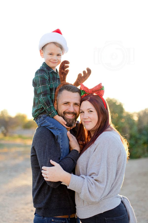 close up portrait of family of three wearing christmas attire for outdoor portrait session during holiday break with olive branch ms photographer danielle jacqueline