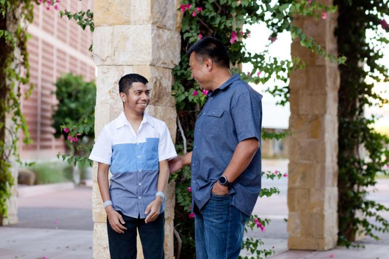 son standing outside with dad laughing special needs services during father's day photography session with danielle jacqueline from desoto county ms