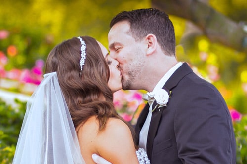 kissing newly married husband and wife during wedding ceremony in memphis tennessee by danielle jacqueline photography beautiful garden background