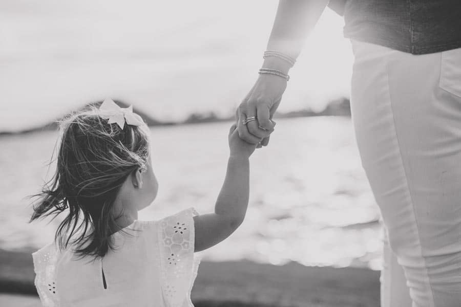 holding the hand of mommy in white jeans on gulfport ms beach for vacation first time seeing ocean cute parent moments with danielle jacqueline