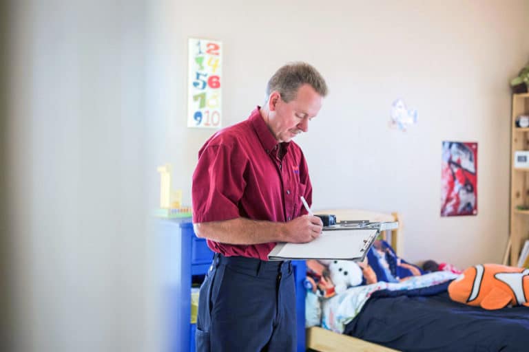 local business owner in kids bedroom writing on clipboard before offering carpet cleaning services photographed by professional danielle jacqueline on location imagery for websites and marketing in memphis tn out of olive branch ms