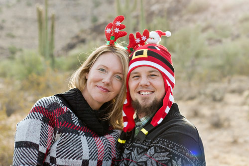 husband and wife wearing holiday stocking hats and christmas sweaters during seasonal photoshoot in nature with danielle jacqueline photography now located in memphis tennessee