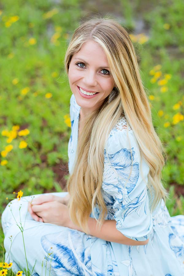 headshot image in baby blue sun dress in field of flowers for about danielle jacqueline photography page in olive branch ms