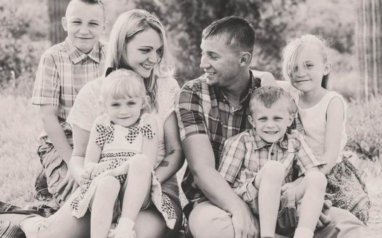 cute little family of 6 portrait with danielle jacqueline outside natural landscape vegetation in back seated on blanket for annual fall photos in germantown tn