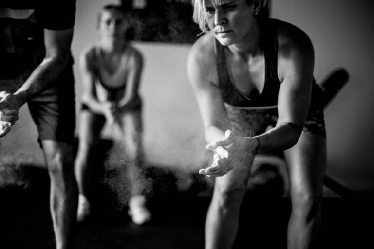 clapping chalk dusting at local gym photography session for women owned businesses by olive branch professional danielle jacqueline black and white employees in back for online marketing imagery