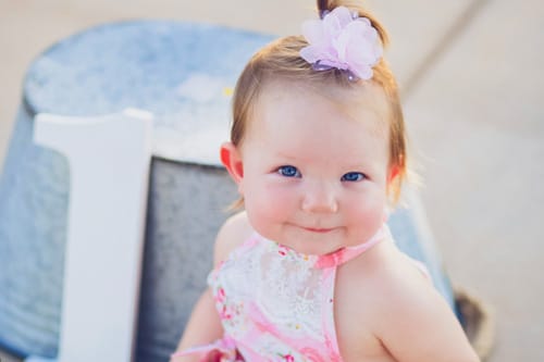 tin trough holding sign of number one for first birthday portraits by danielle jacqueline photography in suburbs southeast memphis review by mother for local business pink dress bow soft highlights