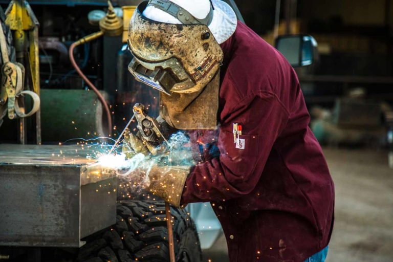 close up up of blue flame sparks flying during welding exhibit in olive branch ms photographed by local business photographer danielle jacqueline fire proof jacket and new company truck formarketing purposes