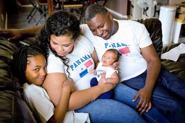 panama immigrants proud to be american celebrating new addition to their family with super happy big sister looking at camera with big smile matching shirts themed family pictures at home on couch with danielle jacqueline now in desoto county ms