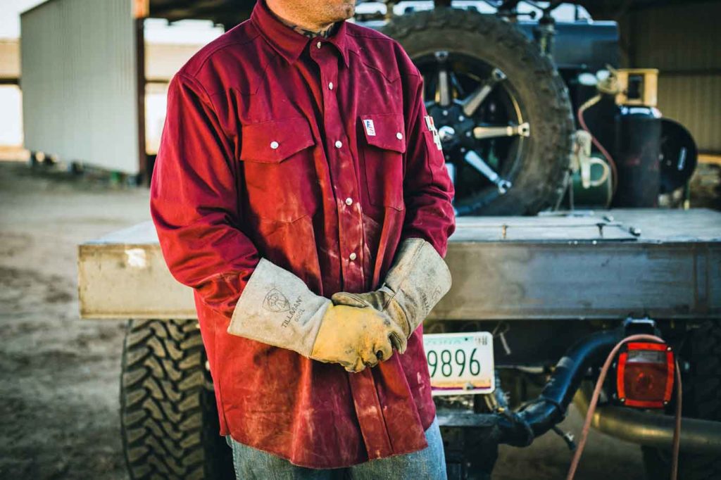 image of hard working man in fire proof apparel about to pull of welding gloves after long day standing next to company truck with business photographer danielle jacqueline out of olive branch ms for online product images