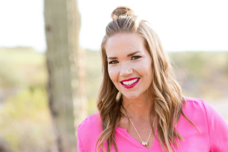 gorgeous businesswoman in pink blouse in front of natural landscape during headshot photography services by danielle jacqueline in olive branch ms red lipstick hair and makeup custom session for personal lifestyle