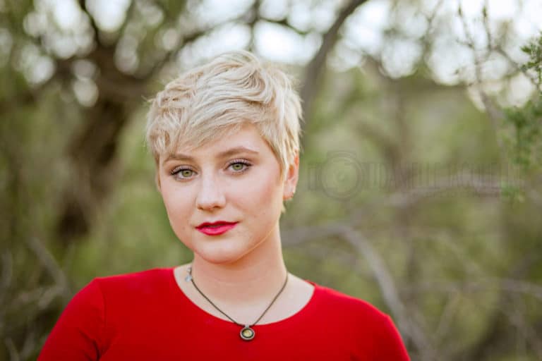 red sweater autumn trees background high school senior graduation portrait bright lipstick short hair blonde attitude for graduation by danielle jacqueline olive branch photography services in mississippi