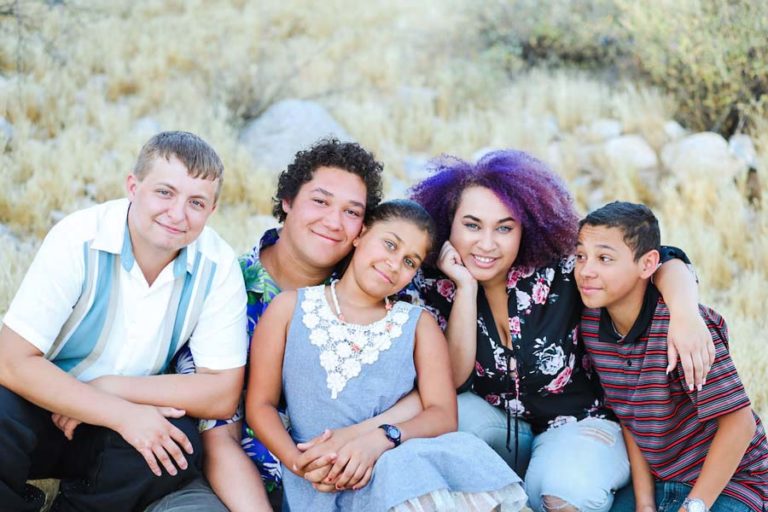 array of characters for sibling photographer children's sessions in olive branch mississippi purple hair blue dress colorful family group in dry natural setting together on rocks by danielle jacqueline